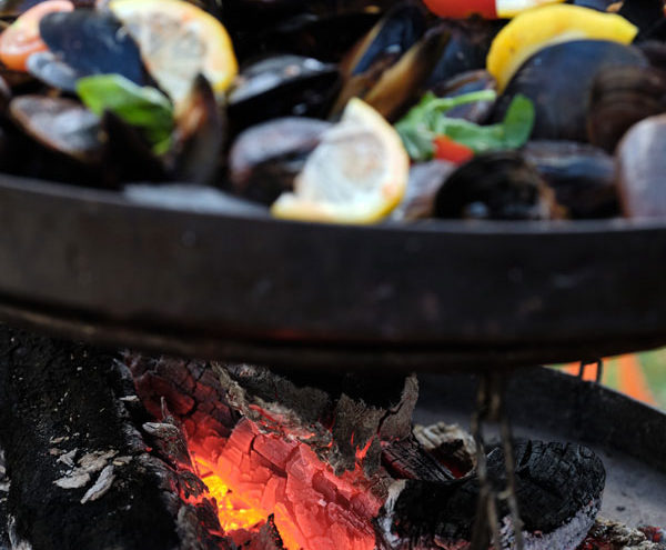 Mussels cooking over open fire